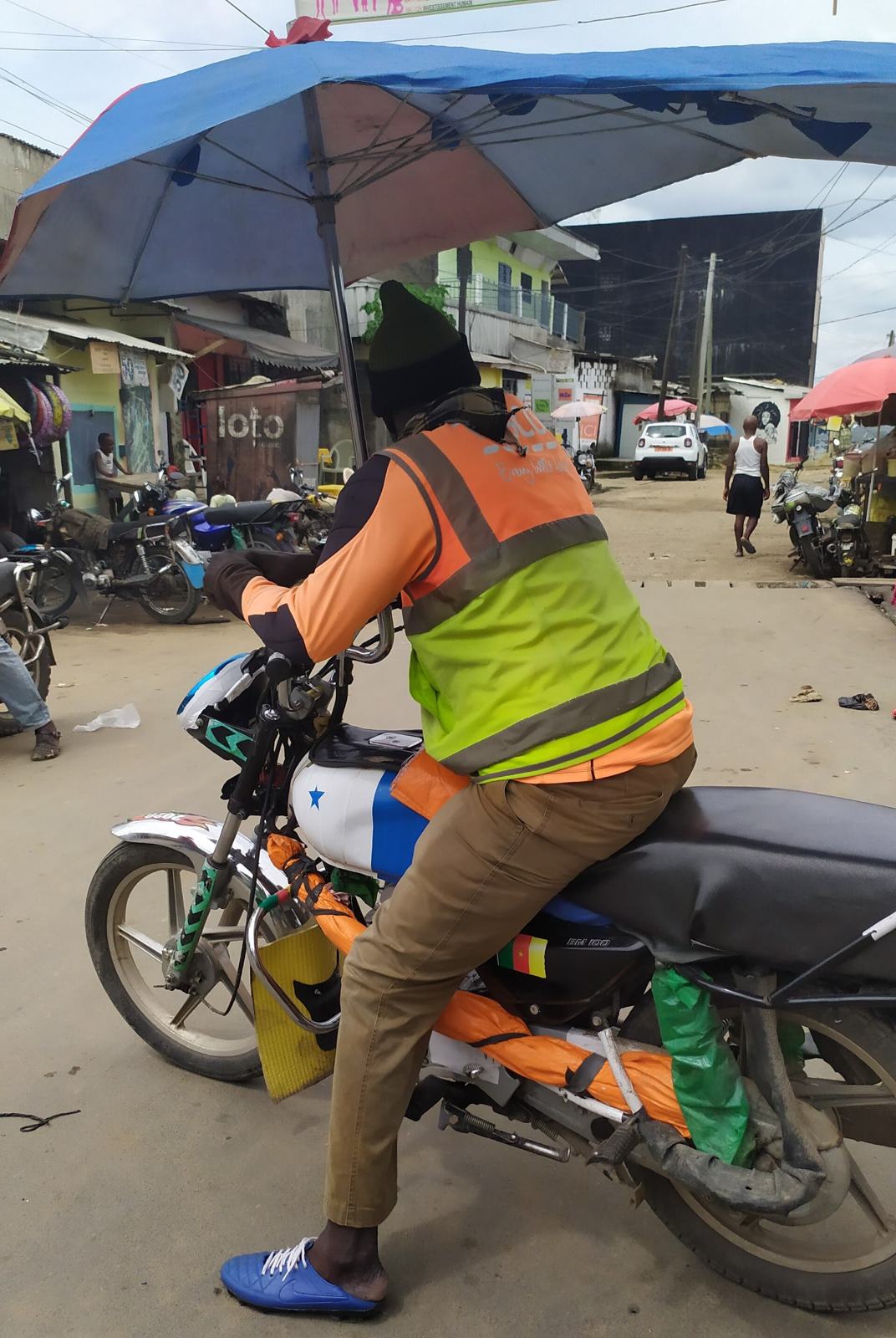 Conducteur de moto-taxi en chasuble à Douala